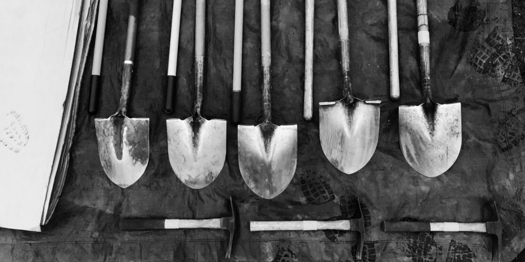 Shovels and tools laying on a tarp. 