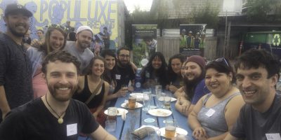 People smiling and sitting around a table with drinks.