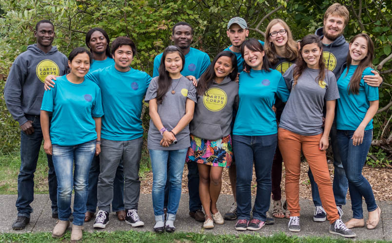 Group of smiling international Corps Members, wearing EarthCorps t-shirts and sweatshirts. 