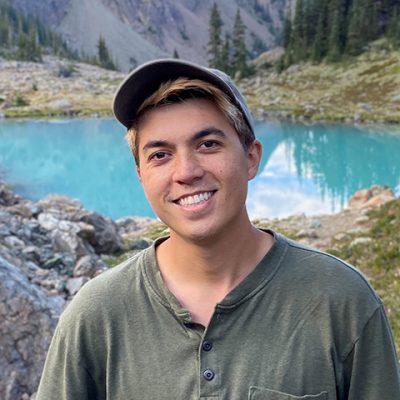 Kyvan standing in front of a lake and mountain