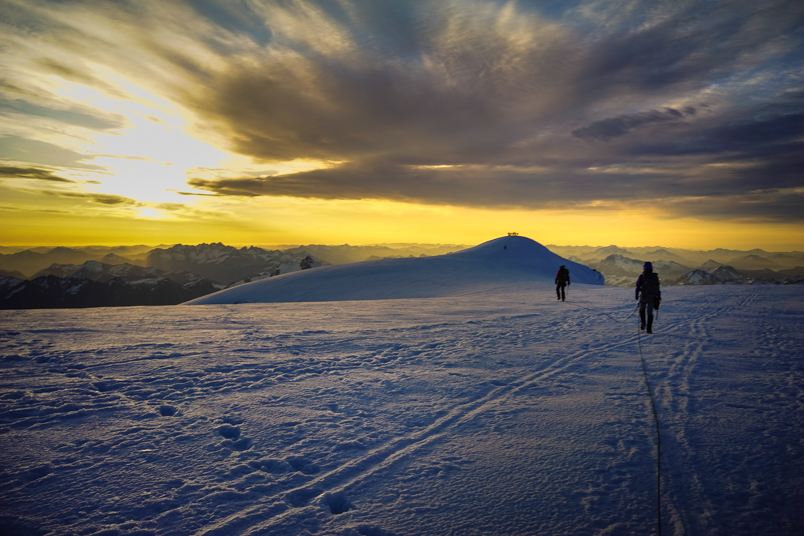 Two people walking on the snow on Mount Baker. 
