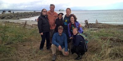 Puget Sound Stewards smiling in front of a body of water.