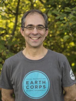 Headshot of EarthCorps Executive Director, Steve Dubiel smiling and wearing an EarthCorps t-shirt.