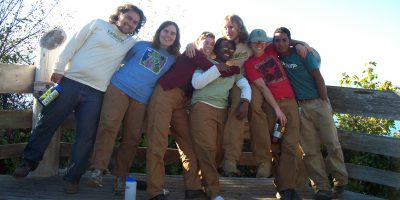 EarthCorps alum, Talasi Brooks and her crew smiling and embracing each other.