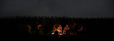 People sitting around a campfire under a starry sky