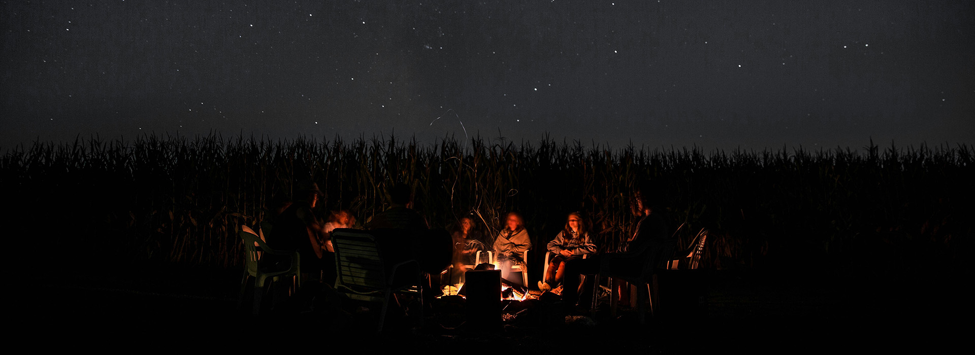 People sitting around a campfire under a starry sky