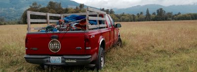 Red EarthCorps truck in a grassy field.